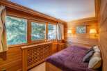 Experience the warmth of this cozy bedroom, featuring stunning wooden paneling and a serene ambiance.