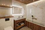 Experience luxury in this stunning bathroom, featuring exquisite marble walls and a warm wooden ceiling.