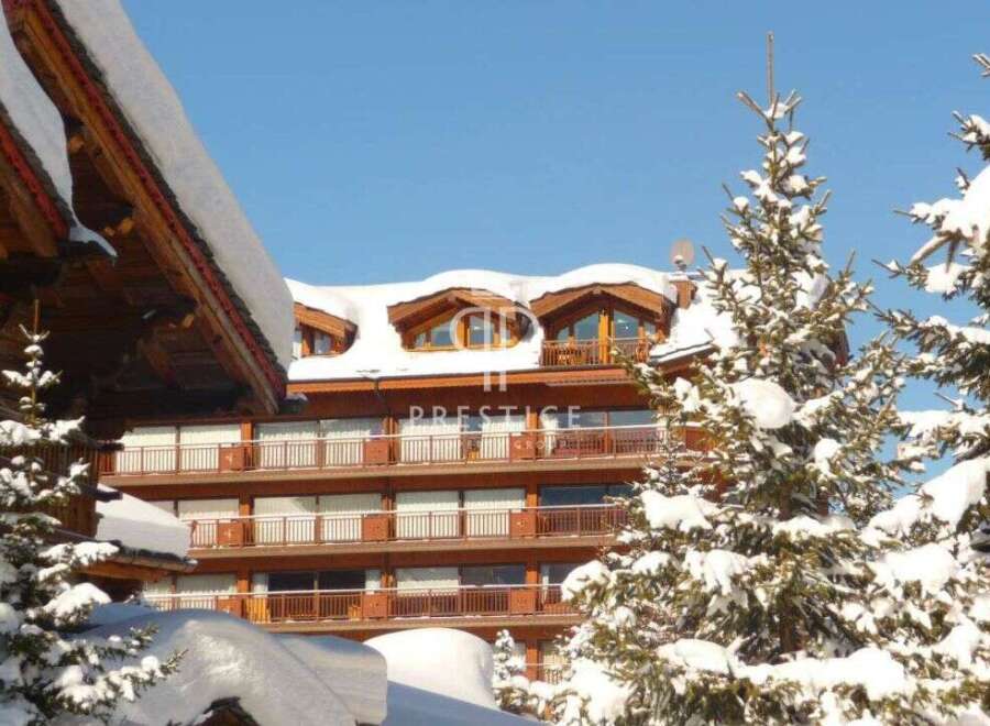Discover a stunning property nestled in a winter wonderland, showcasing exquisite wooden architecture.
