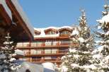 Discover a stunning property nestled in a winter wonderland, showcasing exquisite wooden architecture.