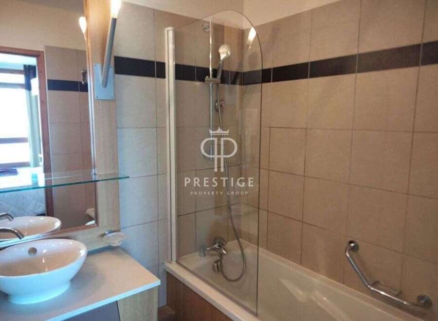 This bathroom features a modern design with a sleek glass shower enclosure.