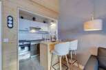 Discover a cozy and stylish apartment with a modern kitchen and a breakfast bar, perfect for intimate meals.