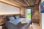Experience luxury in this stunning bedroom featuring exquisite wooden paneling and a cozy ambiance.