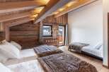 Discover the charm of this cozy bedroom, featuring a rustic wooden ceiling and walls that exude warmth.