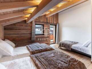 Discover the charm of this cozy bedroom, featuring a rustic wooden ceiling and walls that exude warmth.