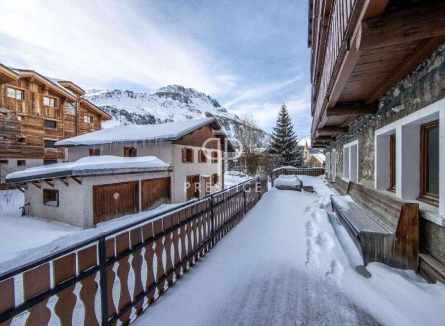 Discover a charming property nestled in a snowy mountain landscape.