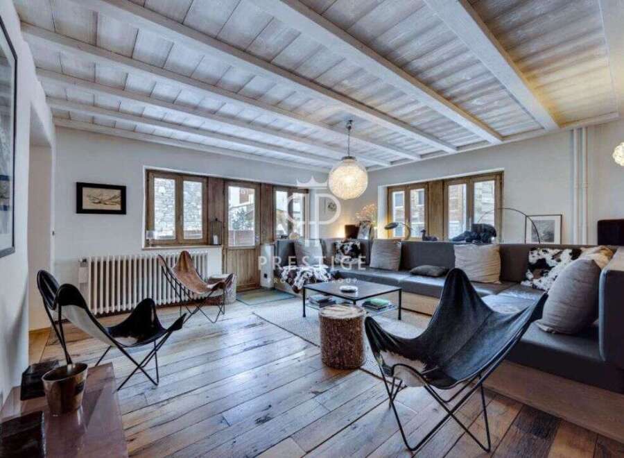Discover the charm of this stunning property, featuring a cozy living room with a unique wooden ceiling and floors.
