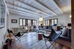 Discover the charm of this stunning property, featuring a cozy living room with a unique wooden ceiling and floors.