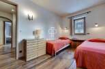 Discover a cozy bedroom with a rustic charm, featuring warm wooden floors and inviting beds.