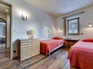 Discover a cozy bedroom with a rustic charm, featuring warm wooden floors and inviting beds.