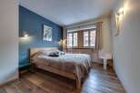 Cozy bedroom with a rustic wooden floor and a comfortable bed.