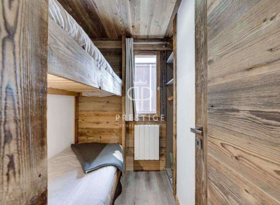 Discover the charm of this cozy bedroom featuring rustic wooden accents and a bunk bed, perfect for a mountain getaway.