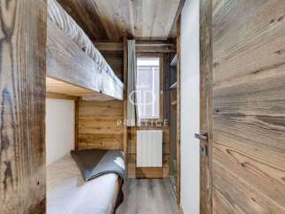 Discover the charm of this cozy bedroom featuring rustic wooden accents and a bunk bed, perfect for a mountain getaway.