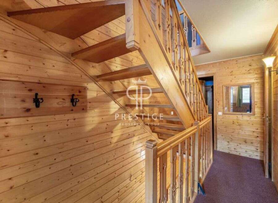 Discover the charm of this wooden-paneled interior, featuring a beautifully crafted staircase.