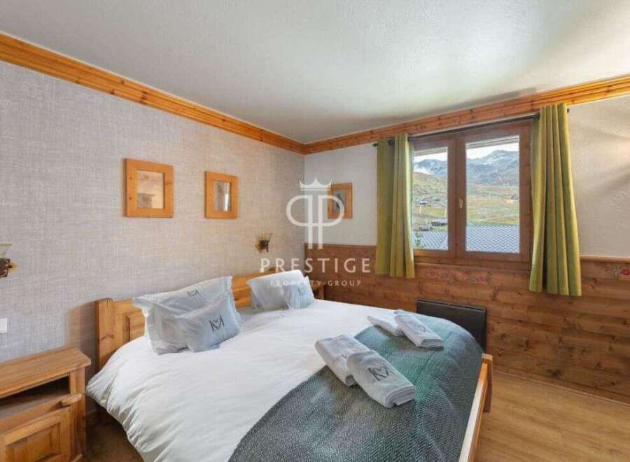 Cozy bedroom with wooden accents and a stunning mountain view.