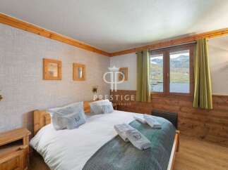 Cozy bedroom with wooden accents and a stunning mountain view.