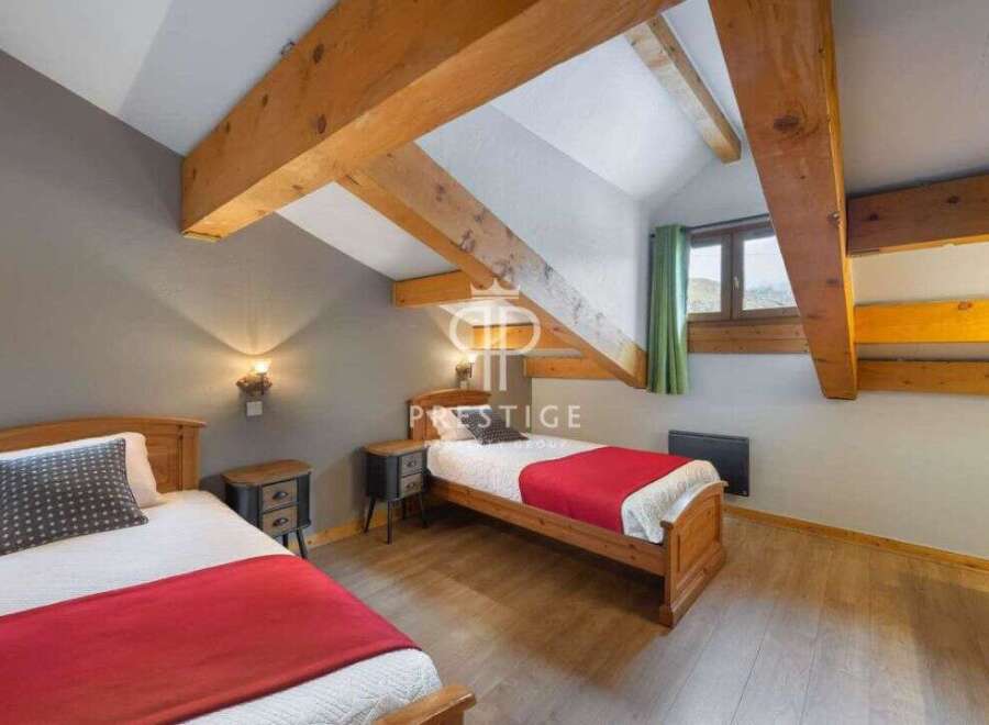 Discover a cozy bedroom with exposed wooden beams, creating a warm and inviting atmosphere.