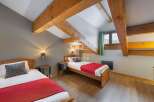 Discover a cozy bedroom with exposed wooden beams, creating a warm and inviting atmosphere.