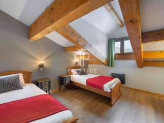Discover a cozy bedroom with exposed wooden beams, creating a warm and inviting atmosphere.