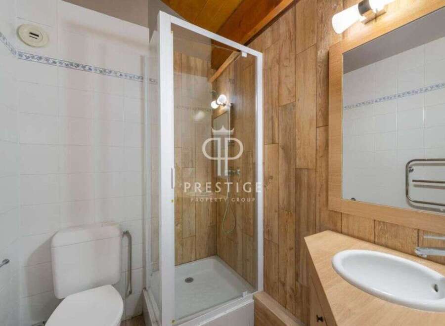 Discover a charming bathroom featuring a modern shower enclosure and stylish wooden paneling.