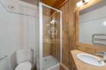 Discover a charming bathroom featuring a modern shower enclosure and stylish wooden paneling.