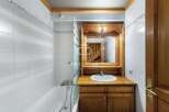 Discover a charming bathroom with a wooden vanity and a sleek white sink.