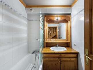 Discover a charming bathroom with a wooden vanity and a sleek white sink.