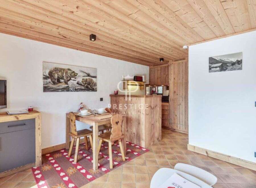 Discover a charming property featuring a cozy dining area with rustic wooden furniture and a unique rug.