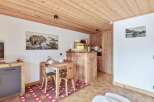 Discover a charming property featuring a cozy dining area with rustic wooden furniture and a unique rug.