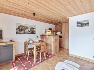 Discover a charming property featuring a cozy dining area with rustic wooden furniture and a unique rug.