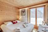 Experience the charm of this cozy bedroom, featuring warm wooden accents and a comfortable bed.