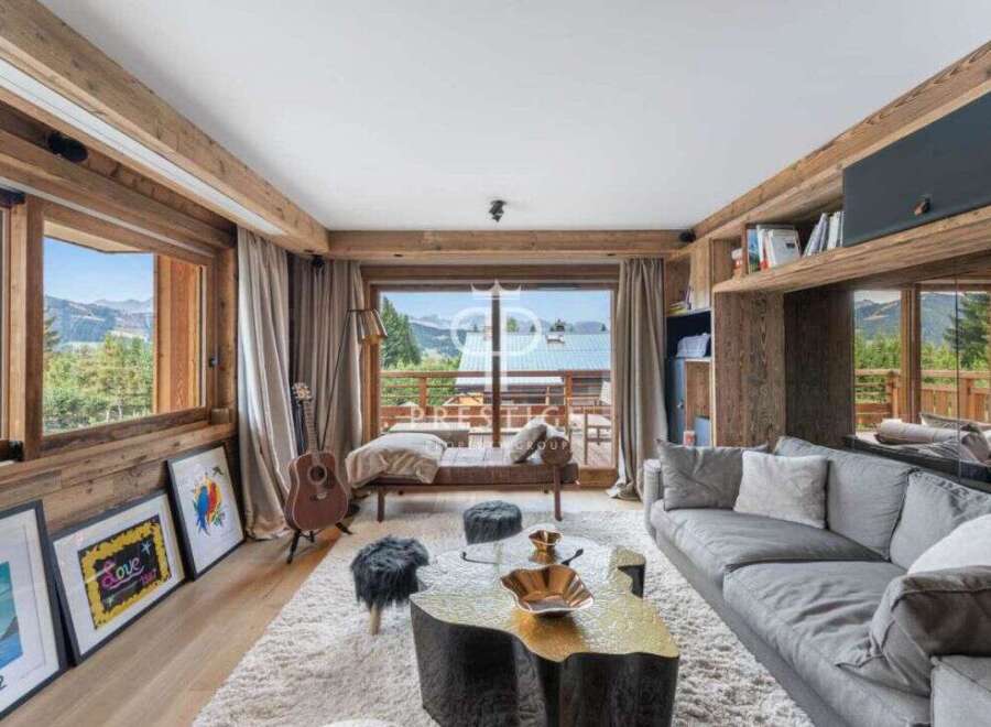 Experience luxury living in this stunning property, featuring a cozy living room with a plush gray sofa and a unique wooden coffee table.