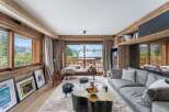 Experience luxury living in this stunning property, featuring a cozy living room with a plush gray sofa and a unique wooden coffee table.