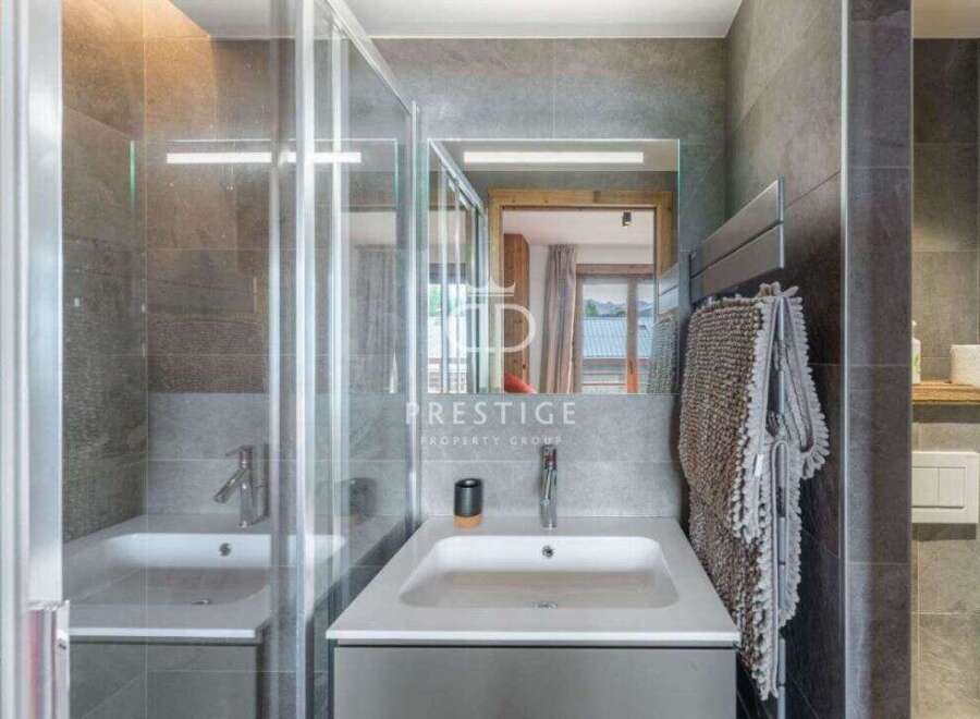 Discover a modern bathroom design featuring a sleek sink and a stylish shower enclosure.