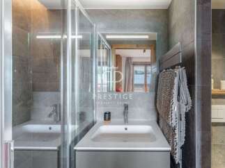 Discover a modern bathroom design featuring a sleek sink and a stylish shower enclosure.