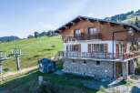 Discover a stunning chalet nestled in a picturesque mountain setting.
