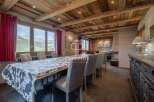 Experience luxury living in this stunning property, featuring a spacious dining area with a unique cowhide tablecloth.
