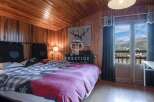 Cozy bedroom with wooden walls and ceiling, creating a warm and inviting atmosphere.
