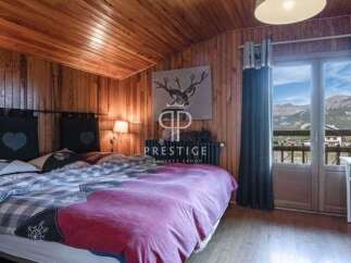 Cozy bedroom with wooden walls and ceiling, creating a warm and inviting atmosphere.