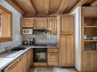 Discover the charm of this cozy kitchen, featuring warm wooden cabinetry and a rustic ceiling.