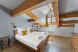 Discover the charm of this cozy bedroom, featuring exposed wooden beams that add warmth and character.