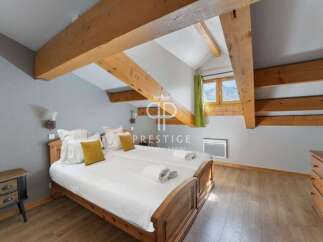 Discover the charm of this cozy bedroom, featuring exposed wooden beams that add warmth and character.