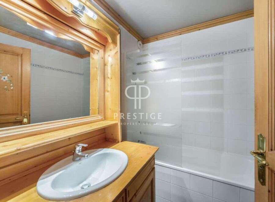 Discover a charming bathroom with a rustic wooden vanity and a sleek white sink.