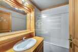 Discover a charming bathroom with a rustic wooden vanity and a sleek white sink.