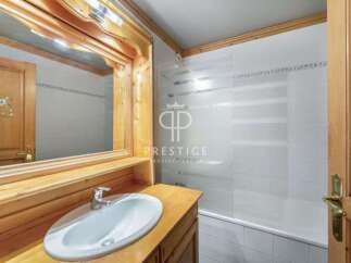 Discover a charming bathroom with a rustic wooden vanity and a sleek white sink.