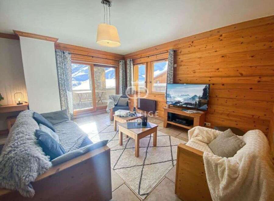 Cozy living room with wooden walls and a stunning mountain view.
