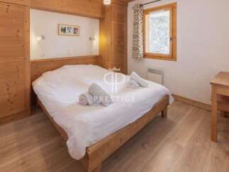 Discover the charm of this cozy bedroom, featuring a warm wooden interior and a comfortable bed.