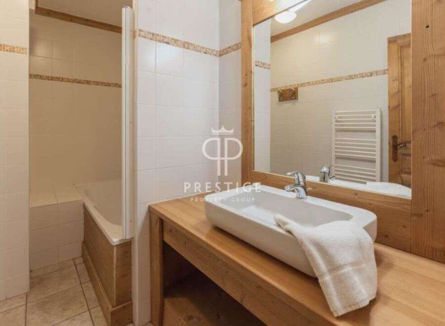 Discover a charming bathroom with a rustic wooden vanity and a sleek, modern sink.