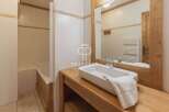 Discover a charming bathroom with a rustic wooden vanity and a sleek, modern sink.