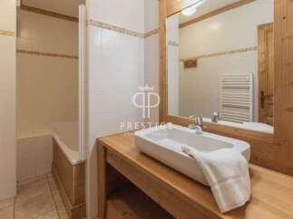 Discover a charming bathroom with a rustic wooden vanity and a sleek, modern sink.